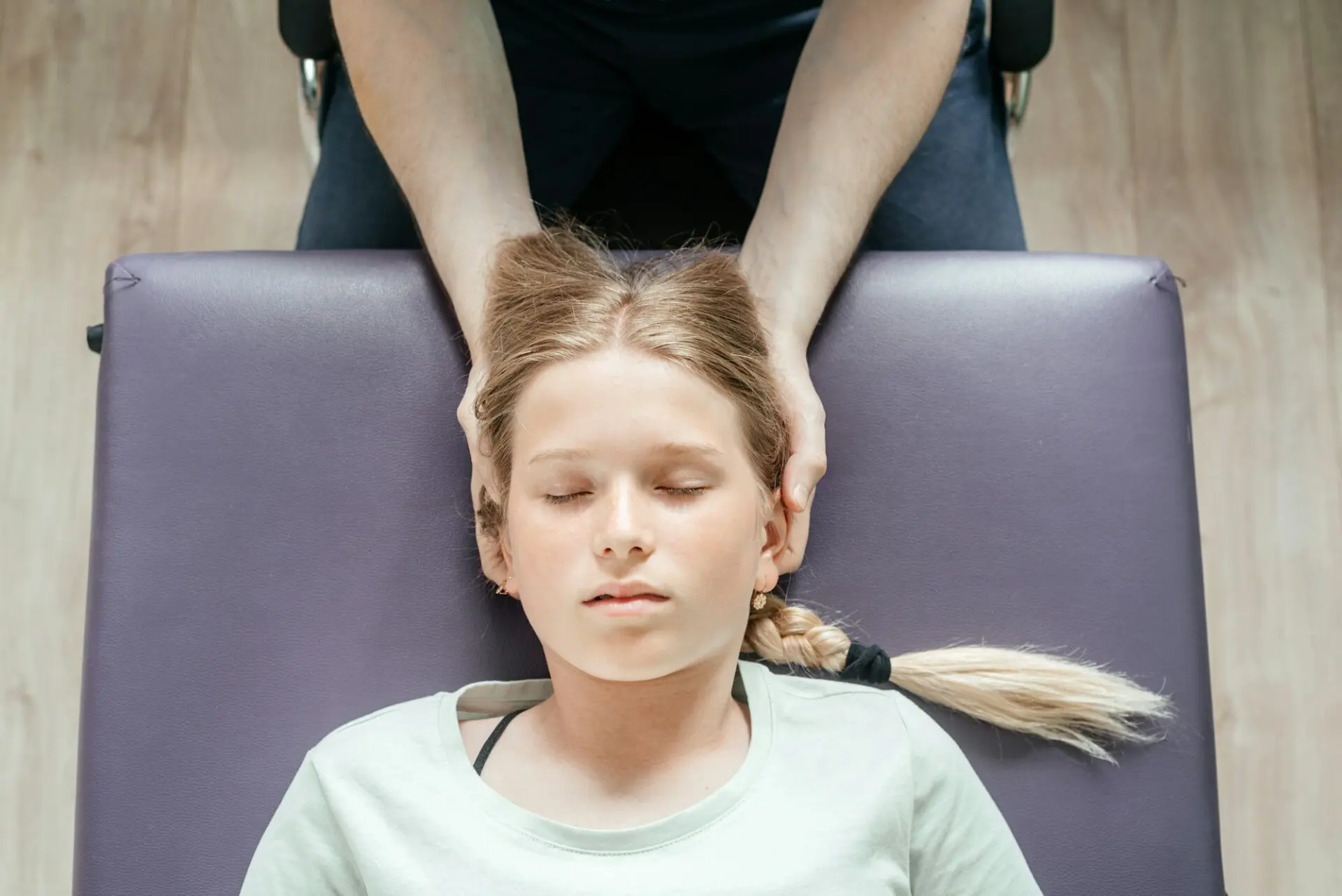 Young girl receiving cranial therapy in clinic